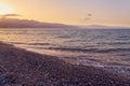 Waves rolled on the pebble beach with the sunset horizon in the background. Royalty Free Stock Photo