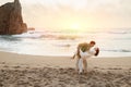 Waves of romance. Young romantic couple dancing on beach at sunset, enjoying date near ocean shore, free space Royalty Free Stock Photo