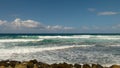 Waves run with snow-white scallops across the blue and turquoise sea