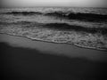 Waves and the sea shore in the evening. Monochrome photo.