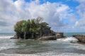 Waves shatter on a cliff at the top of which is the Hindu temple of Tanah Lot. Temple built on a rock in the sea off the coast of Royalty Free Stock Photo