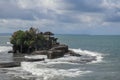 Waves shatter on a cliff at the top of which is the Hindu temple of Tanah Lot. Temple built on a rock in the sea off the coast of Royalty Free Stock Photo