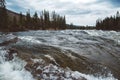 Waves and splashes of mountain river on background of forest, rocks and dramatic sky. Forest river water landscape. Wild river in Royalty Free Stock Photo