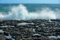 Waves with splashes roll onto rocky shore Royalty Free Stock Photo