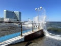 Vladivostok, Russia, October, 10, 2023. Waves on the Sports embankment against the background of the Barny apart-hotel