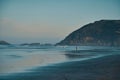 waves and surfers on a flat beach Royalty Free Stock Photo