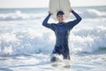 Waves, surfing and man surfer with surfboard at the beach, sea or ocean with a smile and is happy on a summer day Royalty Free Stock Photo