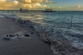 Waves surge onto the beach in front of the pier at Worthing, Sussex in late afternoon Royalty Free Stock Photo