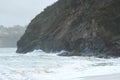 Waves sweeping against the rocks and the beach Royalty Free Stock Photo