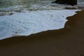 Waves sweeping against the rocks and the beach Royalty Free Stock Photo