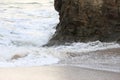 Waves sweeping against the rocks and sand of Carlyon bay in South Cornwall