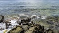 The waves of the turquoise ocean beat against the coastal granite boulders and foam Royalty Free Stock Photo