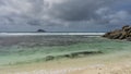 The waves of the turquoise ocean foam over the reef and roll onto the sandy beach Royalty Free Stock Photo