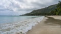 The waves of the turquoise ocean are foaming on the beach. Royalty Free Stock Photo