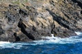 Waves of the turquoise sea crash against rocks of volcanic origin on the island of San Miguel, Portugal. Royalty Free Stock Photo