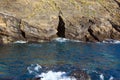 Waves of the turquoise sea crash against rocks of volcanic origin on the island of San Miguel, Portugal. Royalty Free Stock Photo