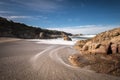 Waves wash onto a small sandy cove near Calvi in Corsica