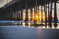 Waves wash over the logs under the dock at sunset. Newport Beach, California Royalty Free Stock Photo