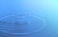 Waves of water are caused by falling droplets. close-up view. Royalty Free Stock Photo