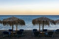 Waves and wind on the beach with umbrellas and sunbeds, lounge chairs on sunset Royalty Free Stock Photo