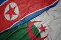 waving colorful flag of algeria and national flag of north korea Royalty Free Stock Photo