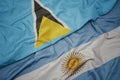 waving colorful flag of argentina and national flag of saint lucia