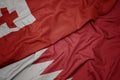 waving colorful flag of bahrain and national flag of Tonga