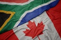 waving colorful flag of canada and national flag of south africa