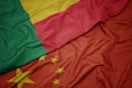 waving colorful flag of china and national flag of benin