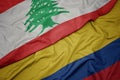 waving colorful flag of colombia and national flag of lebanon