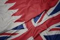 waving colorful flag of great britain and national flag of bahrain