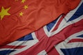 waving colorful flag of great britain and national flag of china