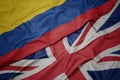 waving colorful flag of great britain and national flag of colombia