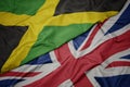 waving colorful flag of great britain and national flag of jamaica