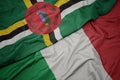 waving colorful flag of italy and national flag of dominica