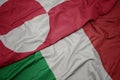 waving colorful flag of italy and national flag of greenland
