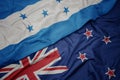 waving colorful flag of new zealand and national flag of honduras