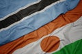 waving colorful flag of niger and national flag of botswana Royalty Free Stock Photo