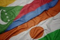 waving colorful flag of niger and national flag of comoros Royalty Free Stock Photo