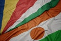 waving colorful flag of niger and national flag of seychelles Royalty Free Stock Photo