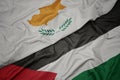 waving colorful flag of palestine and national flag of cyprus