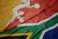 waving colorful flag of south africa and national flag of bhutan Royalty Free Stock Photo