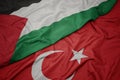waving colorful flag of turkey and national flag of palestine