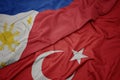 waving colorful flag of turkey and national flag of philippines