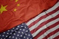 waving colorful flag of united states of america and national flag of china