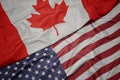 waving colorful flag of united states of america and national flag of canada