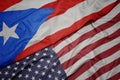 waving colorful flag of united states of america and national flag of puerto rico