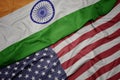 waving colorful flag of united states of america and national flag of india