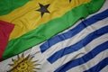 waving colorful flag of uruguay and national flag of sao tome and principe