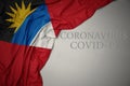 waving national flag of antigua and barbuda on a gray background with text coronavirus covid-19 . concept Royalty Free Stock Photo